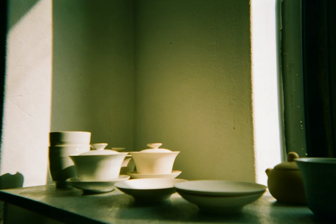 White porcelain bowls on a sill by a sunlit window